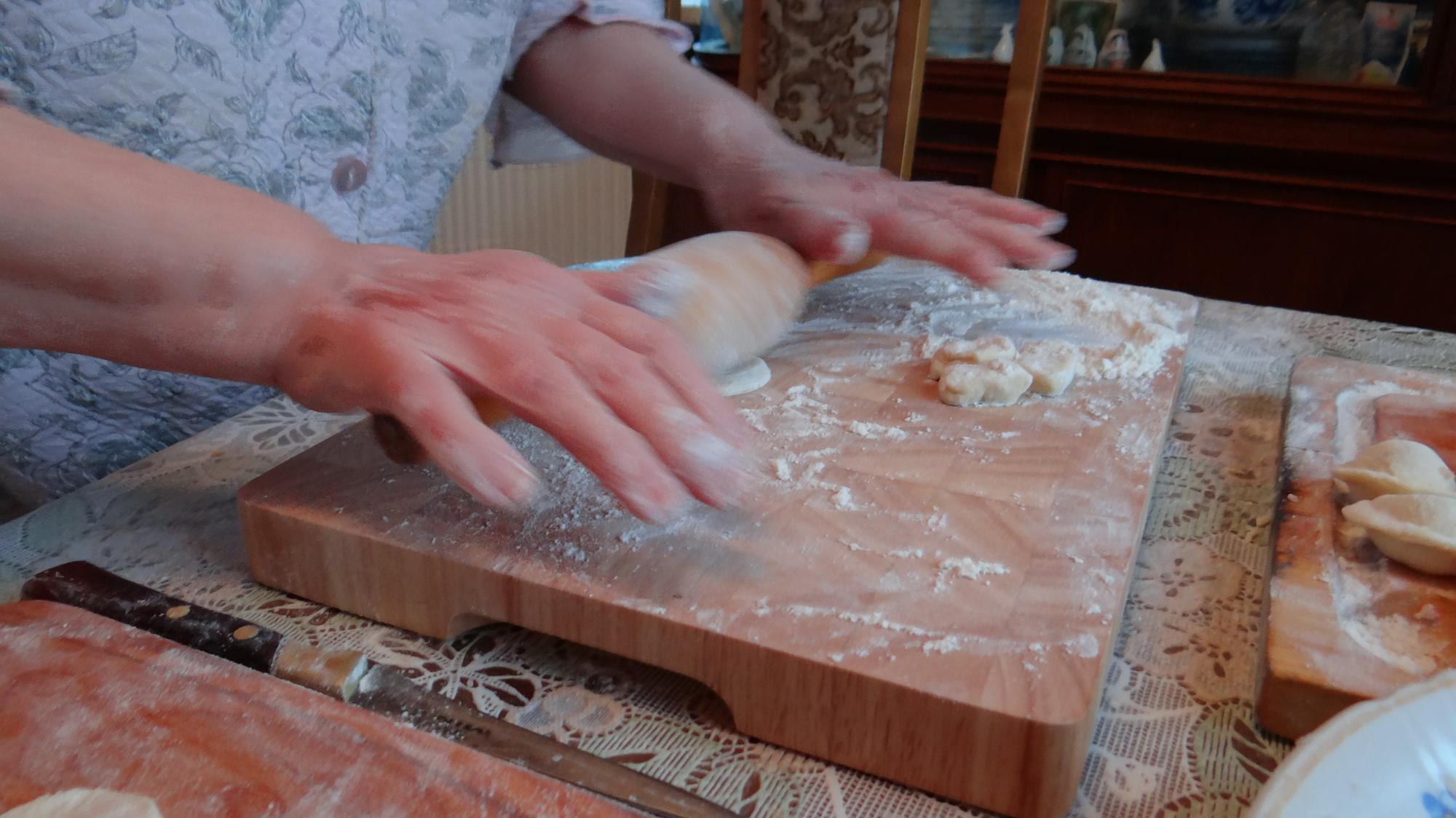 Close-up of hands kneading dough on wooden table