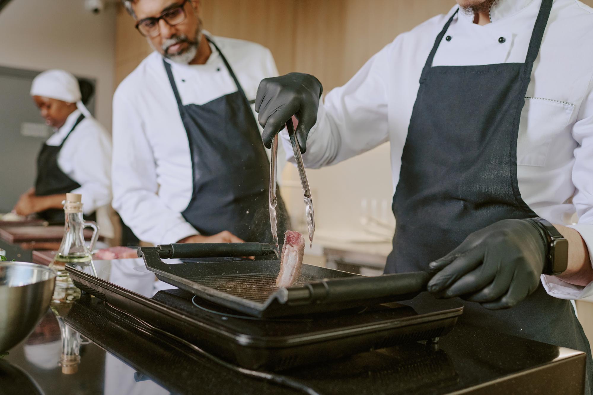 Instructor guiding participant while searing fish